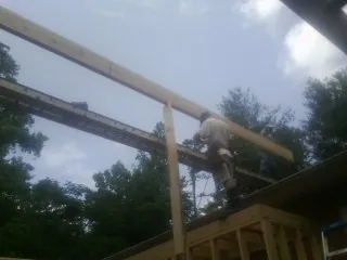 Carpenter setting a ridge beam over a new addition frame — Ice Dam Removal by Roofing Brothers in Hunters