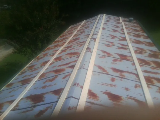 Rusted metal roof panels with new wood purlins before replacement — Storm Damage Roof Repair in Hunters by Roofing Brothers
