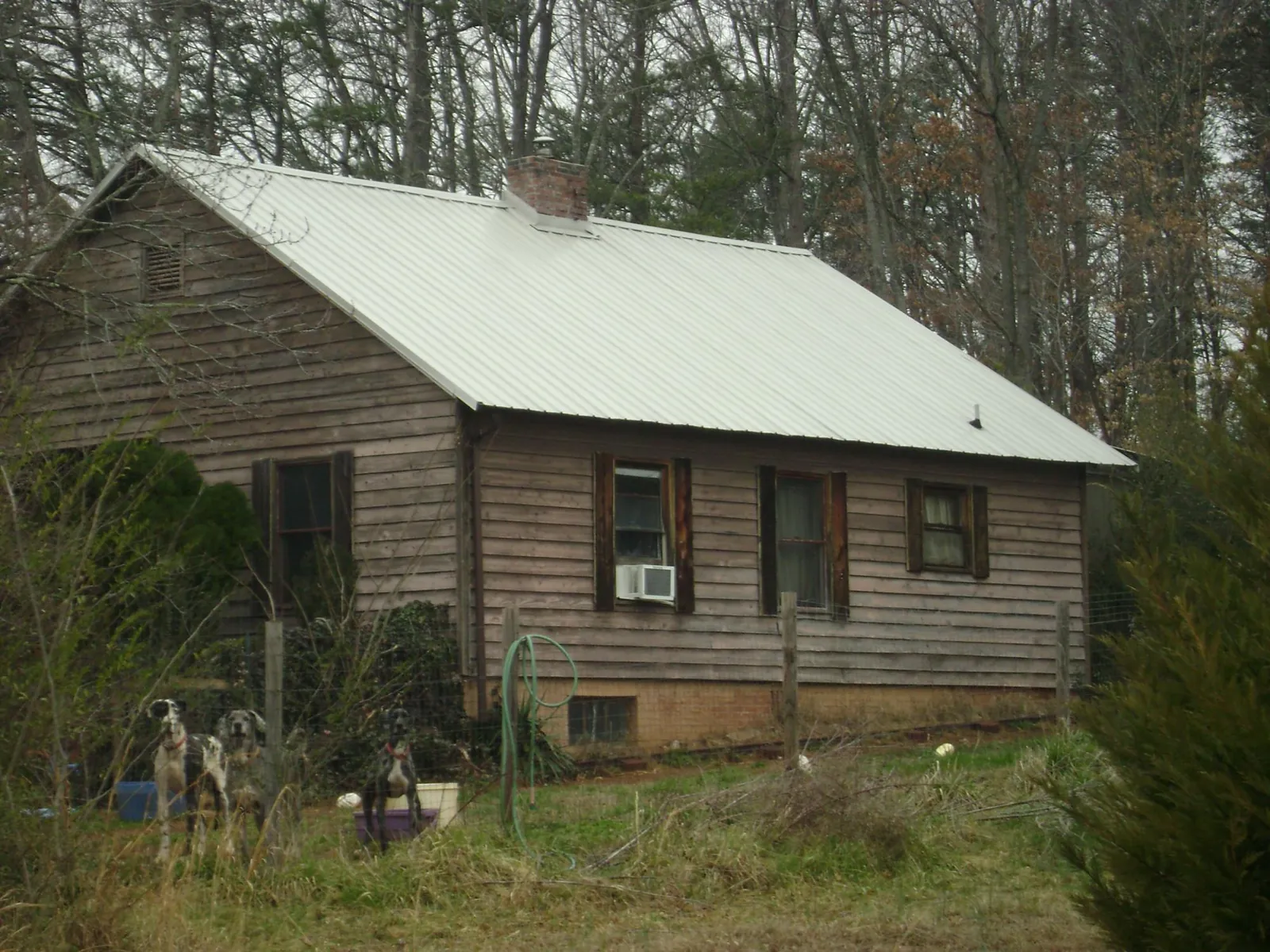 White metal roof on an old wood sided farmhouse, from a Metal Roof Installation job in Hunters